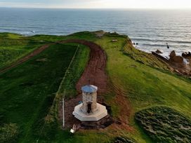 An aerial view of a gazebo on a cliff overlooking the ocean at The Dairy in Bridgerule