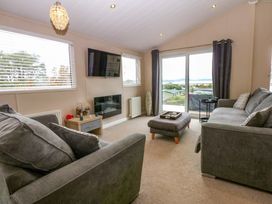 A living room with a sofa and television at The Hideaway in Pwllheli