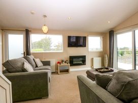 A living room with a sofa and television at The Hideaway in Pwllheli