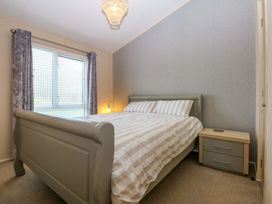 A bedroom with a bed and nightstand at The Hideaway in Pwllheli