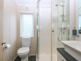 A bathroom with a shower and toilet at The Hideaway in Pwllheli