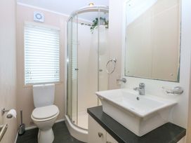 A bathroom with a shower, sink, and toilet at The Hideaway in Pwllheli