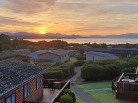 A sunset view over a holiday park with houses and mountains at The Hideaway in Pwllheli