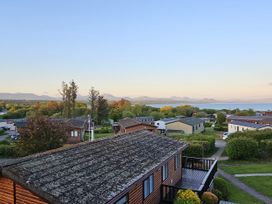 A view of houses and mountains near a lake at The Hideaway Pwllheli