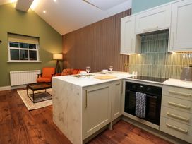 A kitchen with an island, oven, sink, and seating area at The Studio in Windermere