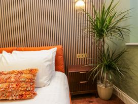 A bedroom with a sofa and a plant at The Studio in Windermere