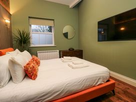 A bedroom with a bed and television at The Studio in Windermere