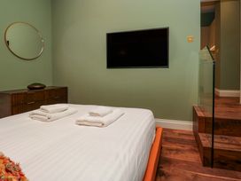 A bedroom with a bed and television at The Studio in Windermere