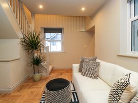 A living room with a couch and plant at The Coach House in Windermere