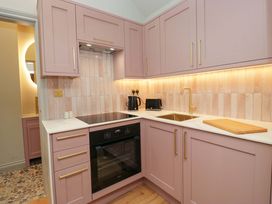 A kitchen with pink cabinets and appliances at The Coach House in Windermere