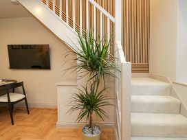 A staircase with a plant and television in the entryway at The Coach House Windermere