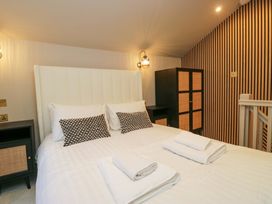 A bedroom with a bed and a wardrobe at The Coach House in Windermere
