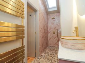 A bathroom with a shower and wash basin at The Coach House in Windermere