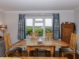 A dining room with a wooden table and window at 8 Thurlestone Rock in Kingsbridge