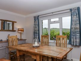 A dining area with a wooden table and chairs at 8 Thurlestone Rock in Kingsbridge