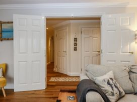 A living room with open doors and a couch at 8 Thurlestone Rock in Kingsbridge