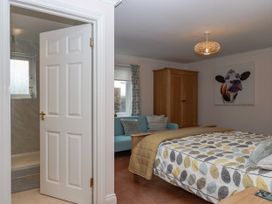 A bedroom with a bed, wardrobe, and couch at 8 Thurlestone Rock in Kingsbridge