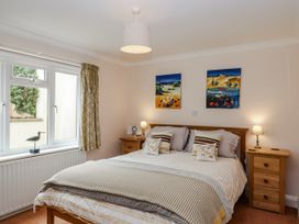 A bedroom with a bed and wall art at 8 Thurlestone Rock in Kingsbridge