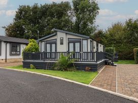 A mobile home with a deck and palm tree at Whistler in Wimborne