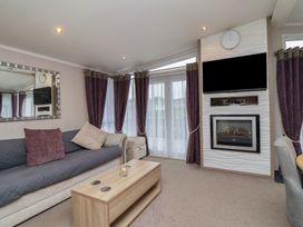 A living room with a sofa and a television at Whistler in Wimborne