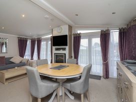 A living room with a sofa and dining table at Whistler in Wimborne