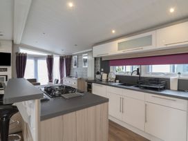 A kitchen with a gas stove and sink at Whistler in Wimborne