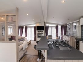 An open plan living area with kitchen and seating at Whistler in Wimborne