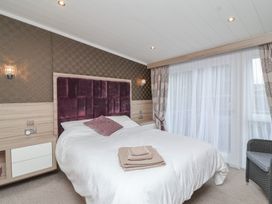 A bedroom with a bed and sliding door at Whistler in Wimborne