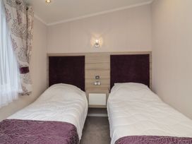 A bedroom with twin beds and curtains at Whistler in Wimborne