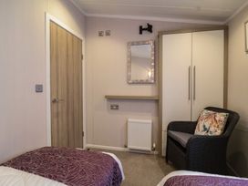 A bedroom with a wardrobe and chair at Whistler in Wimborne