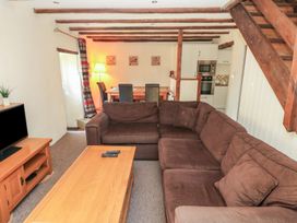 A living room with a sofa and coffee table at Carthouse Cottage in Clarbeston Road