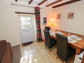 A dining room with a wooden table and chairs at Carthouse Cottage Clarbeston Road