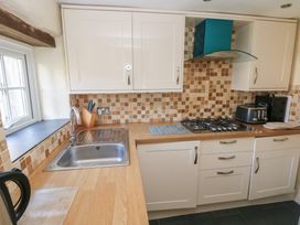 A kitchen with cabinets and appliances at Carthouse Cottage in Clarbeston Road