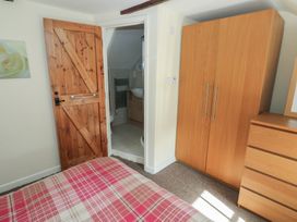 A bedroom with a bed and wardrobe at Carthouse Cottage in Clarbeston Road