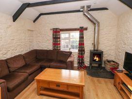 A living room with a sofa and stove at Knap Cottage in Clarbeston Road