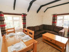 A living room with a dining table set and a sofa at Knap Cottage in Clarbeston Road