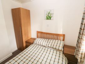 A bedroom with a bed and a wardrobe at Knap Cottage in Clarbeston Road