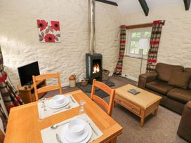 A living room with a sofa, table, and television at Corner Cottage in Clarbeston Road