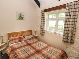 A bedroom with a bed and window at Corner Cottage in Clarbeston Road