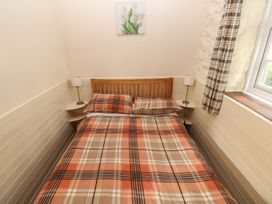 A bedroom with a bed and bedside table at Corner Cottage in Clarbeston Road