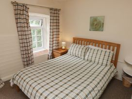 A bedroom with a bed and window at Stable Cottage in Clarbeston Road