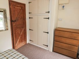 A bedroom with a wooden door and dresser at Stable Cottage in Clarbeston Road