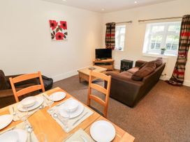 A living room with a sofa and a dining table at Swallows Cottage in Clarbeston Road