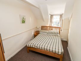 A bedroom with a bed and nightstand at Swallows Cottage in Clarbeston Road
