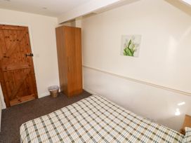 A bedroom with a bed and wardrobe at Swallows Cottage in Clarbeston Road