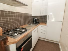 A kitchen with a stove and refrigerator at Shippen Cottage in Clarbeston Road