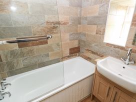 A bathroom with a bathtub and wash basin at Shippen Cottage Clarbeston Road