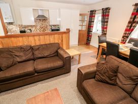 A living room with sofas and a dining area at Lake Cottage in Clarbeston Road