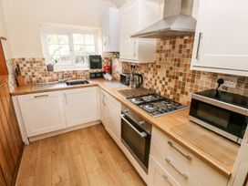 A kitchen with cabinets and appliances at Lake Cottage in Clarbeston Road