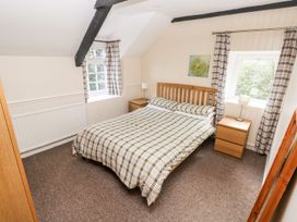 A bedroom with a bed and nightstands at Lake Cottage in Clarbeston Road